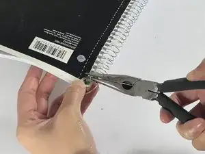 Как исправить погнутую спиральную пружину и укрепить порванные отверстия на блокноте